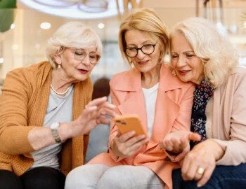 Three senior female friends enjoying vacation time in hotel cafe