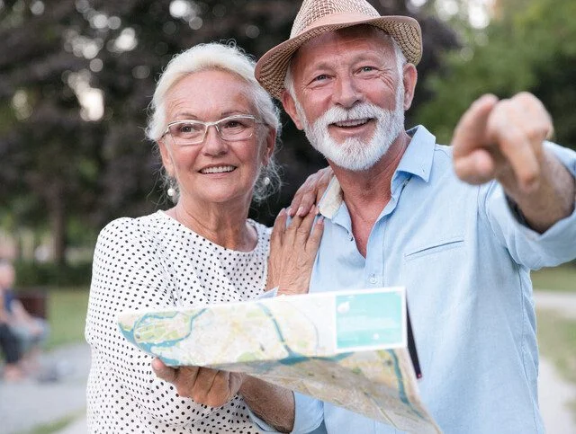 Smiling mature woman hugging a man pointing direction