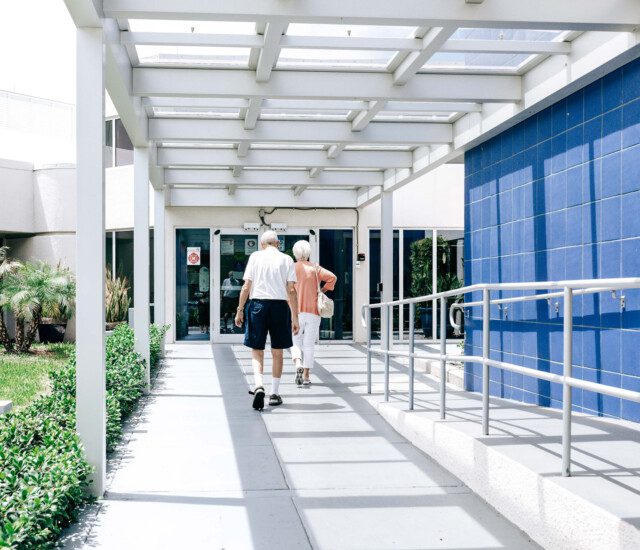 senior couple walks towards the entrance of the health center at Harbiyr;