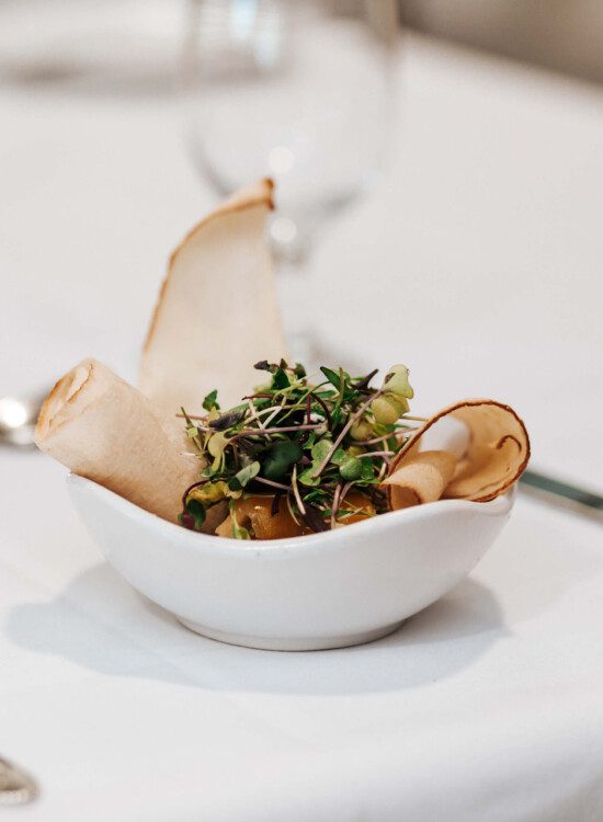 close-up of beautifully plated upscale dish on a white-cloth table