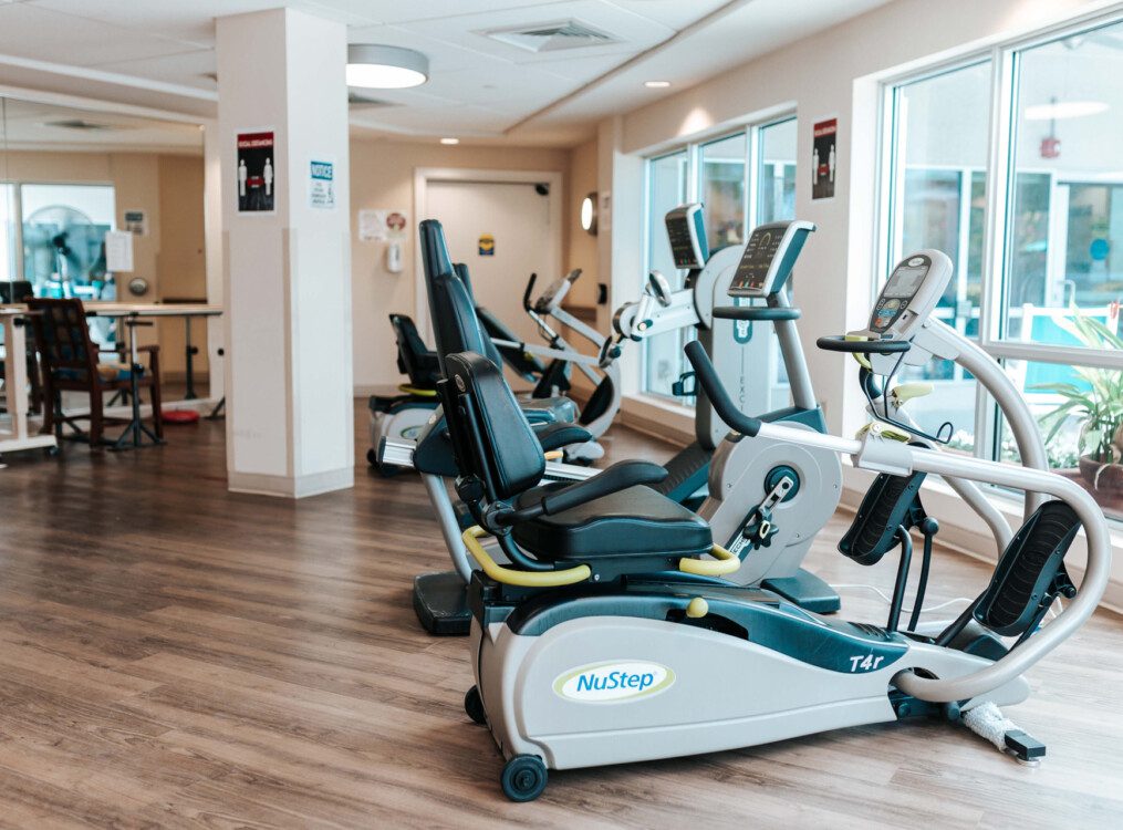 reclining bicycles and fitness equipment in the fitness center at Harbour's Edge Senior Living Community