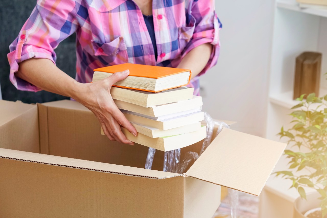 senior woman packing books into a box