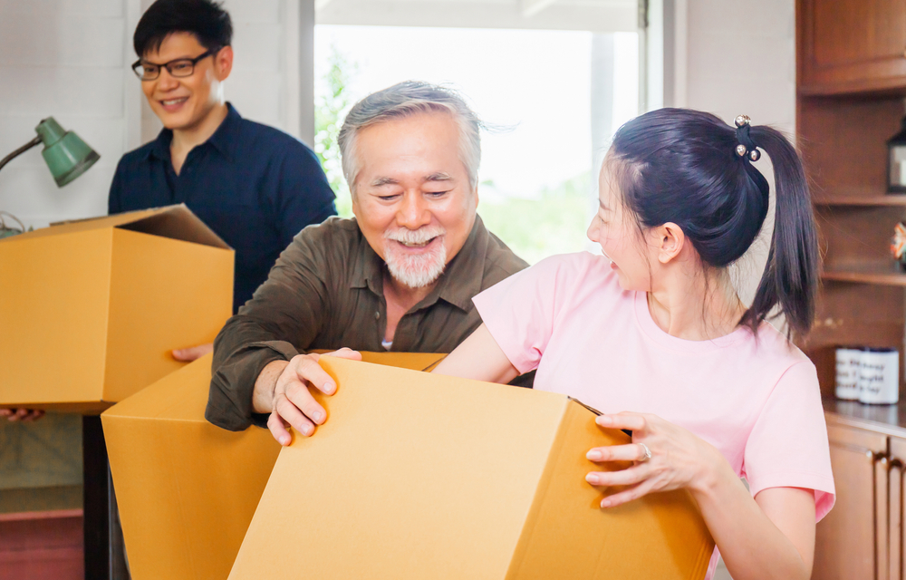 Senior man and his family packing up moving boxes