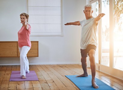 two seniors practicing yoga in a sunny room
