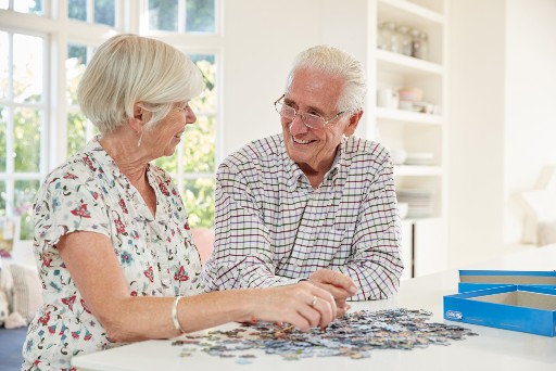 senior couple putting together a puzzle in their senior apartment