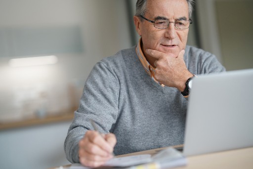 senior man on a laptop studying for an online course