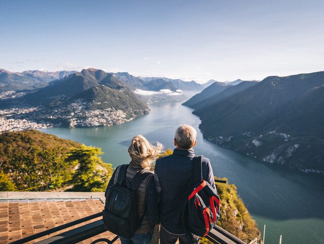 Older adult couple admiring scenic mountain views on a hike.