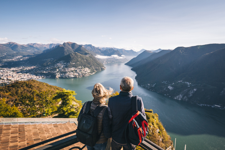 Older adult couple admiring scenic mountain views on a hike.