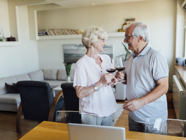 Older adult couple enjoying some red wine together.