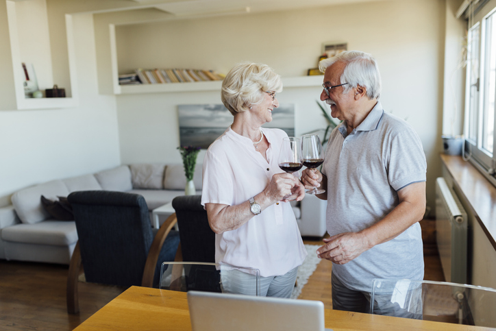 Older adult couple enjoying some red wine together.