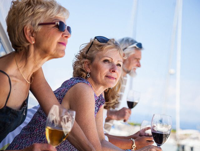Older adults enjoying nice weather and wine outdoors.