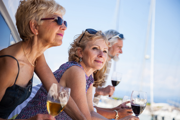 Older adults enjoying nice weather and wine outdoors.